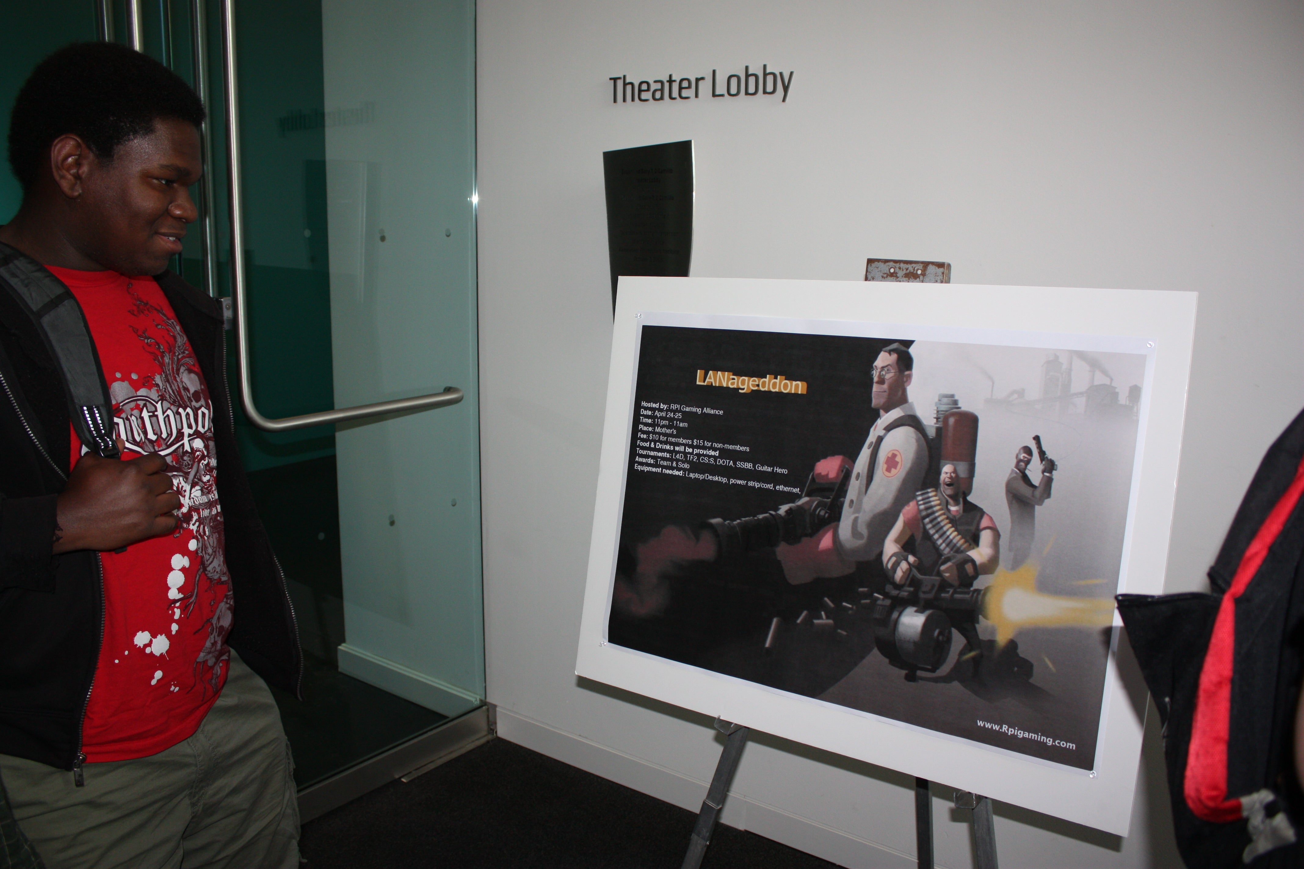 A student looking at a poster for LANageddon at GameFest 2009.