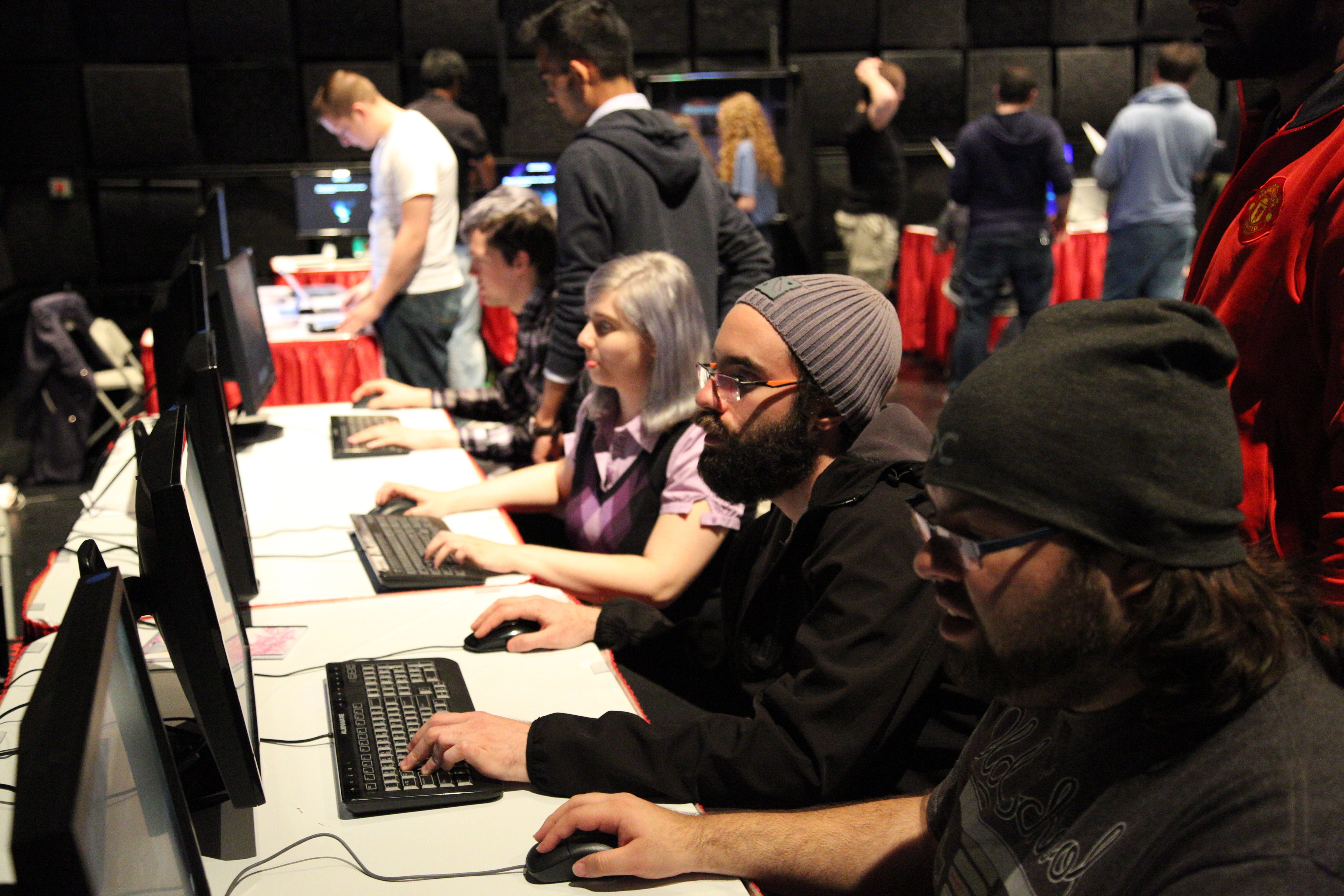 Students playing games at three booths during GameFest 2016.