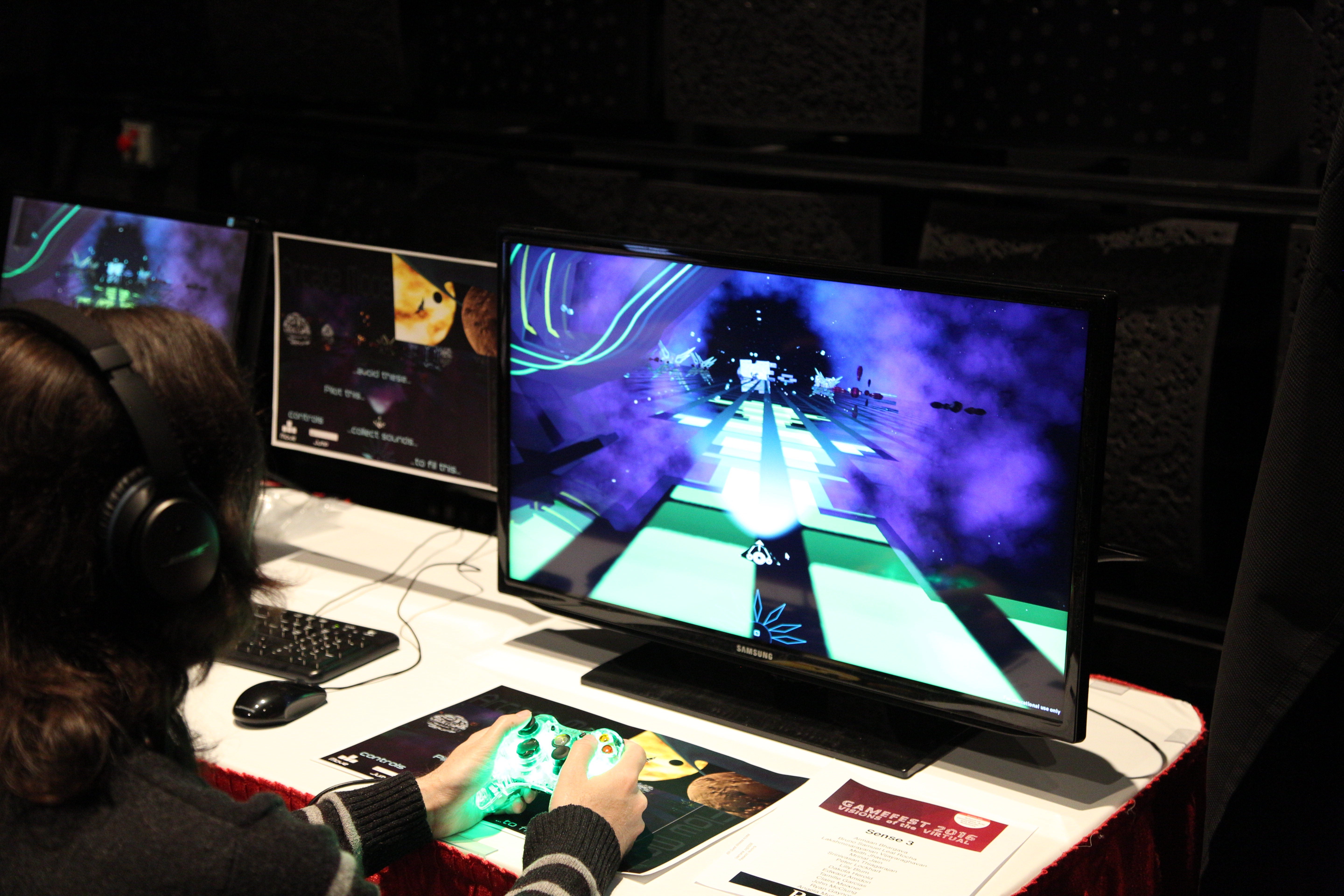 A student controlling a side-scrolling ship with a controller at GameFest 2016.